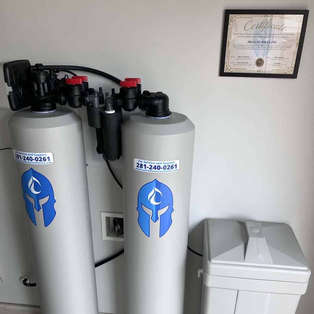 Water softener and filter tanks with brine tank installed in a garage by United Water Softeners