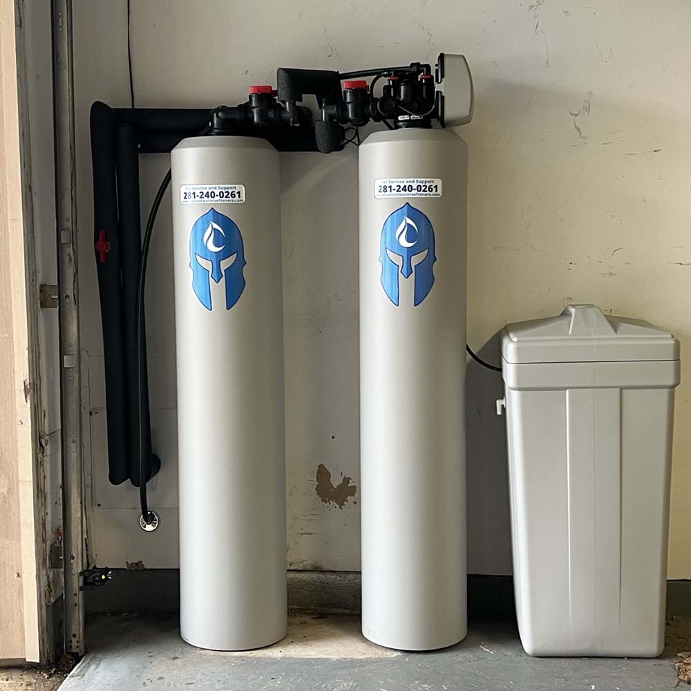 Elite Package whole-house water softener and carbon filtration system professionally installed in the corner of a garage in Cypress, Texas by United Water Softeners – Houston’s #1 rated water company.