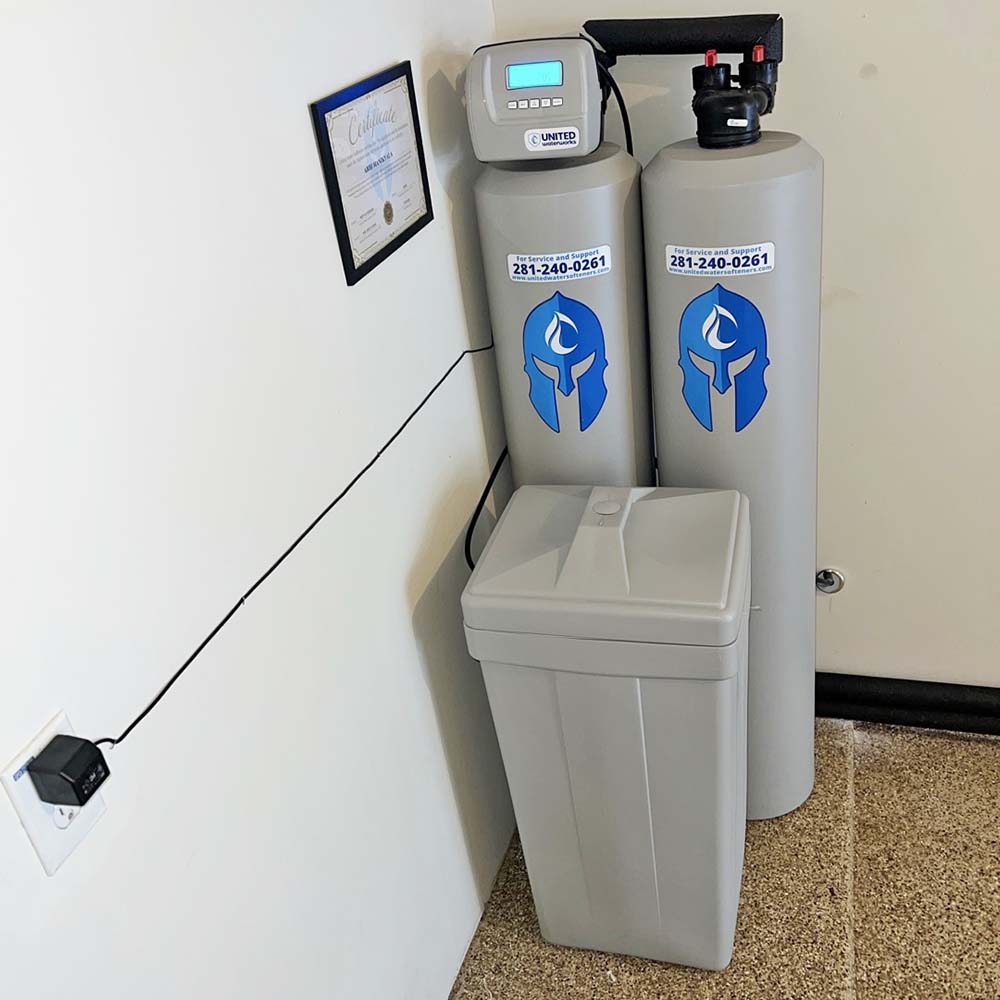 Elite Package whole-house water softener and carbon filtration system professionally installed in the back of a garage in Richmond, Texas by United Water Softeners – Houston’s #1 rated water company.