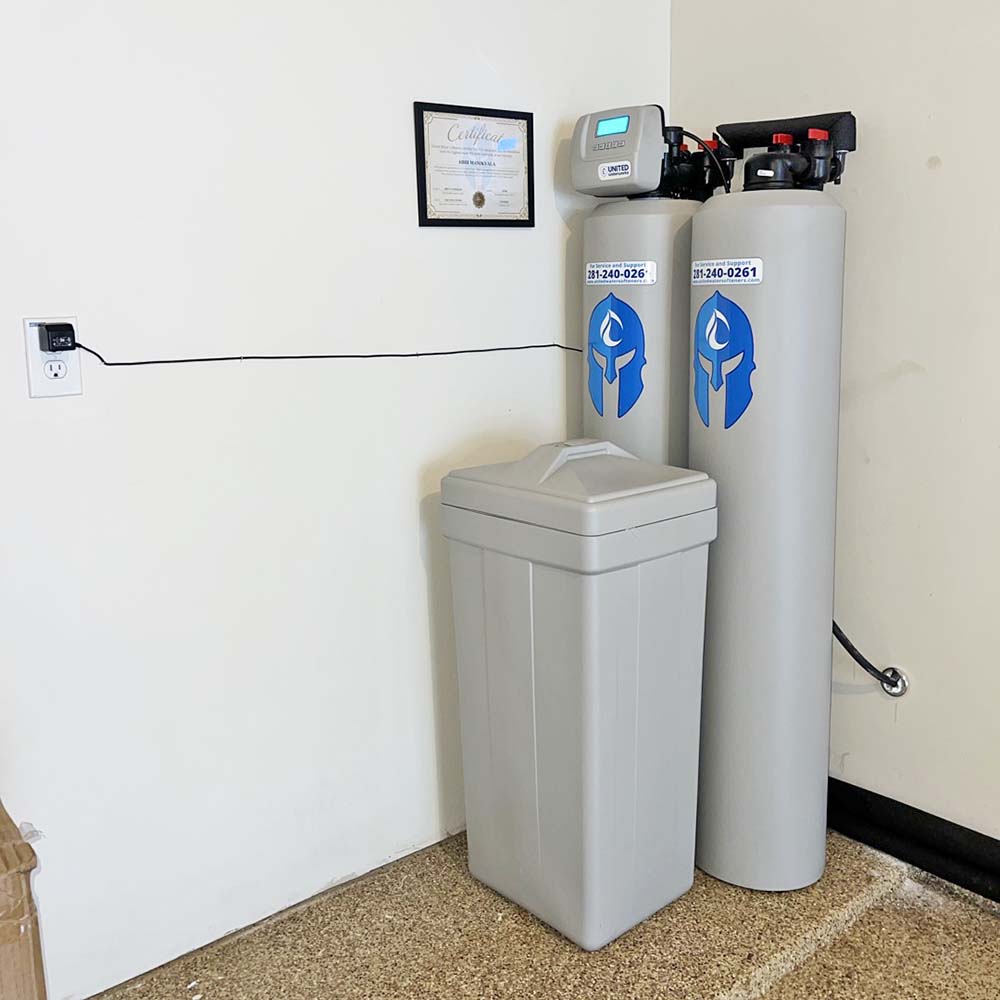 Elite Package whole-house water softener and carbon filtration system professionally installed in the back of a garage in Richmond, Texas by United Water Softeners – Houston’s #1 rated water company.